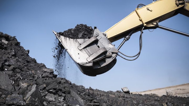 Digger lifting coal from opencast coalmine