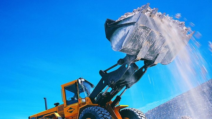 Backhoe lifting rubble
