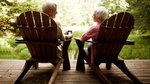Senior Couple Lounging in Adirondack Chairs on a Wood Deck